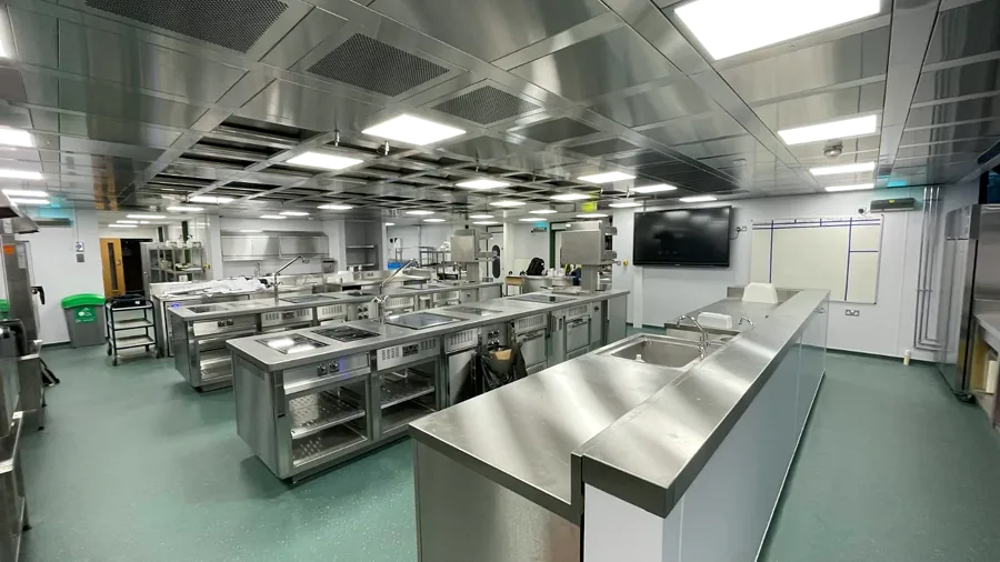 Large stainless-steel teaching kitchen with multiple workstations
