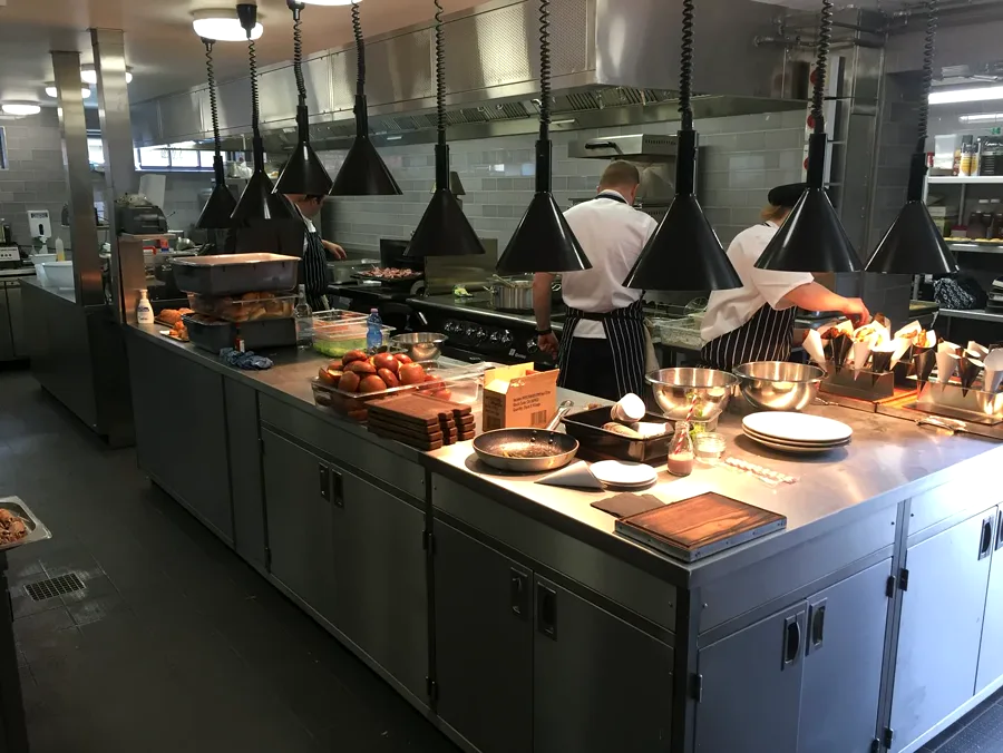 Chefs working at a high-output commercial kitchen pass