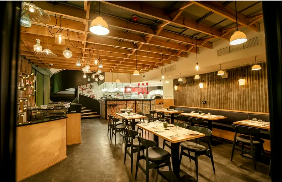 Warm timber restaurant dining room with open kitchen beyond